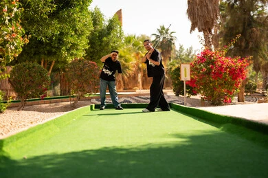 شباب سعودي يلعبون ميني غولف في حديقة خارجية