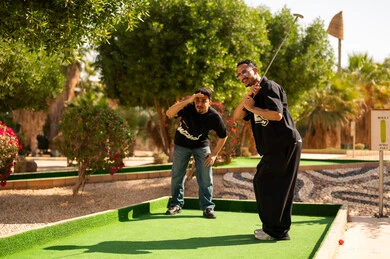 شباب عرب يلعبون الميني غولف في ملعب خارجي