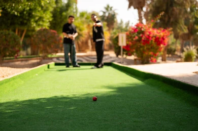 رجال عرب يلعبون الميني غولف في ملعب خارجي