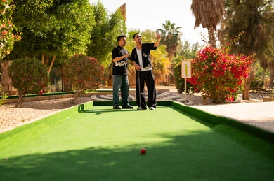 شابان عربيان يلعبان الغولف المصغر في الهواء الطلق