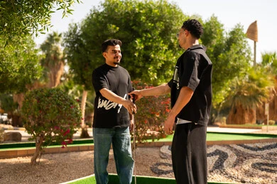 شباب سعوديون يتصافحون في ملعب جولف