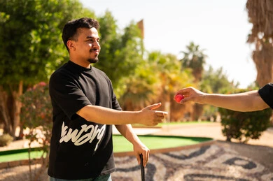 شاب سعودي يلعب الغولف المصغر في الهواء الطلق