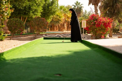 امرأة سعودية بالعباءة تلعب الغولف المصغر بالخارج امرأة سعودية بالعباءة تلعب الغولف المصغر بالخارج