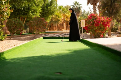 امرأة سعودية تلعب الميني غولف في حديقة خارجية