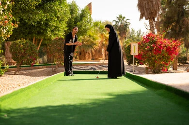 زوجان سعوديان يلعبان الميني غولف في منتزه خارجي