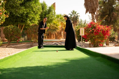 زوجان سعوديان يلعبان الميني غولف في منتزه خارجي