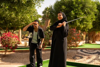 زوجان سعوديان يلعبان الغولف المصغر في الهواء الطلق