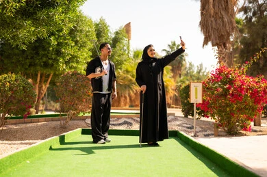 زوجين إماراتيين يلعبان ميني غولف ويلتقطان سيلفي