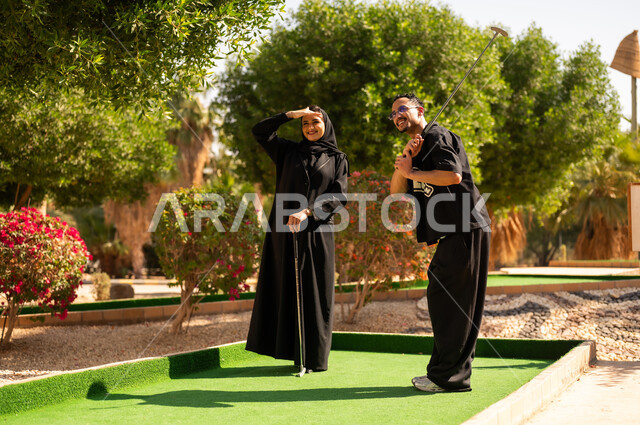 Saudi Couple Playing Mini Golf in Outdoor Park