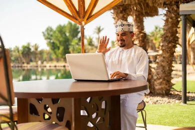 رجل عماني يعمل على المحمول في الهواء الطلق