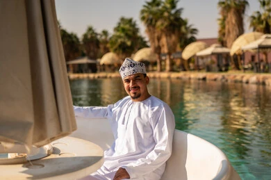 رجل عماني بالزي التقليدي في قارب ببحيرة المنتجع