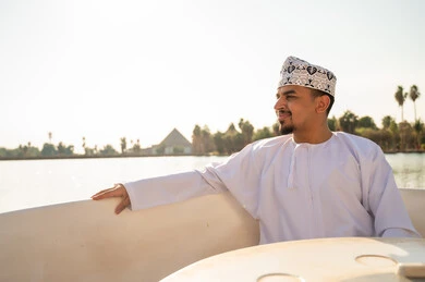 رجل عماني بالزي التقليدي في رحلة بحرية