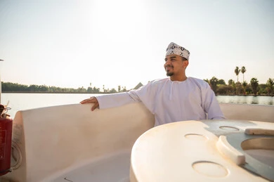 رجل عماني بالزي التقليدي على متن قارب
