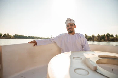 رجل عُماني بالزي التقليدي على متن قارب