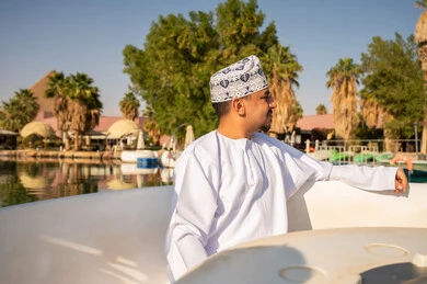 رجل عماني بالزي التقليدي في قارب بالمنتجع