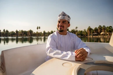 Omani Man in Traditional Dress on Pedal Boat Lake