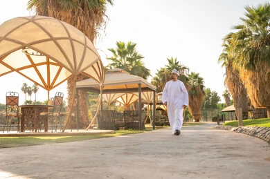 رجل عماني بالزي التقليدي يسير في منتجع سياحي