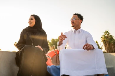 رجل وامرأة سعوديان على قارب وقت الغروب