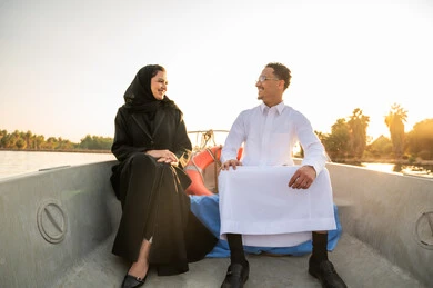 زوجين سعوديين في رحلة قارب وقت الغروب الذهبي