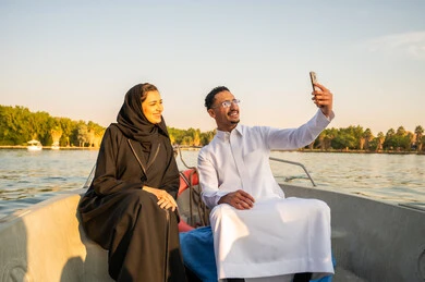 زوجين سعوديين يلتقطان سيلفي على قارب وقت الغروب