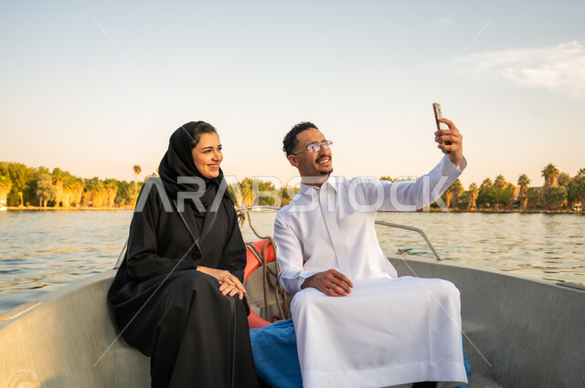 Saudi Couple Taking Selfie on Boat at Sunset