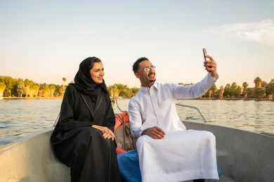 زوجان سعوديان يلتقطان سيلفي على متن قارب وقت الغروب