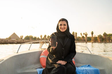 Saudi Woman with Smartphone on Boat near Giza Pyramid
