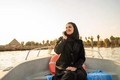 امرأة سعودية على قارب مع إطلالة غروب الشمس والهرم