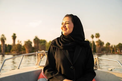 امرأة سعودية على متن قارب وقت الغروب