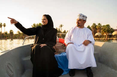 زوجين عمانيين في رحلة بحرية وقت الغروب