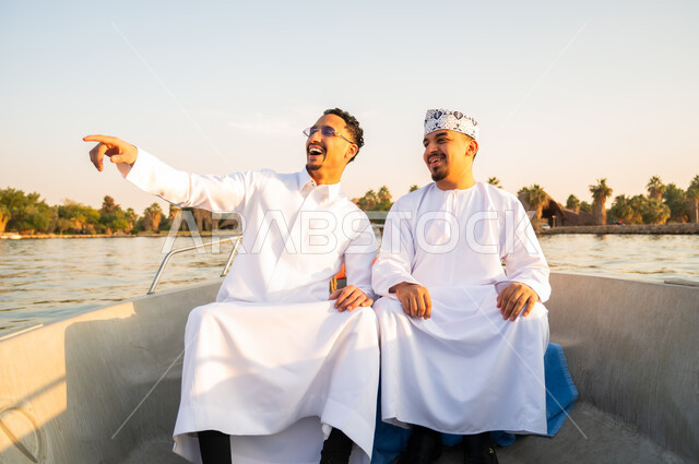 رجال عمانيون في رحلة قارب وقت الغروب