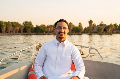 رجل سعودي بالثوب الأبيض على متن قارب وقت الغروب