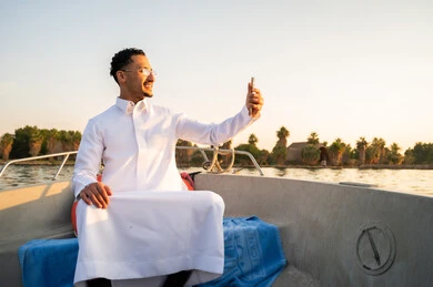 رجل سعودي بالثوب الأبيض يلتقط سيلفي في القارب
