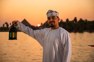رجل عماني يحمل فانوس رمضان أمام أهرامات الجيزة