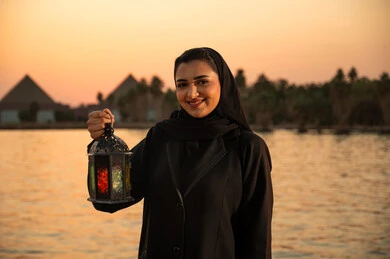 امرأة مصرية تحمل فانوس رمضان أمام أهرامات الجيزة