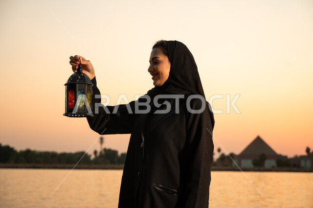 امرأة سعودية تحمل فانوس رمضان وقت الغروب