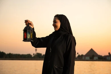 امرأة سعودية تحمل فانوس رمضان وقت الغروب