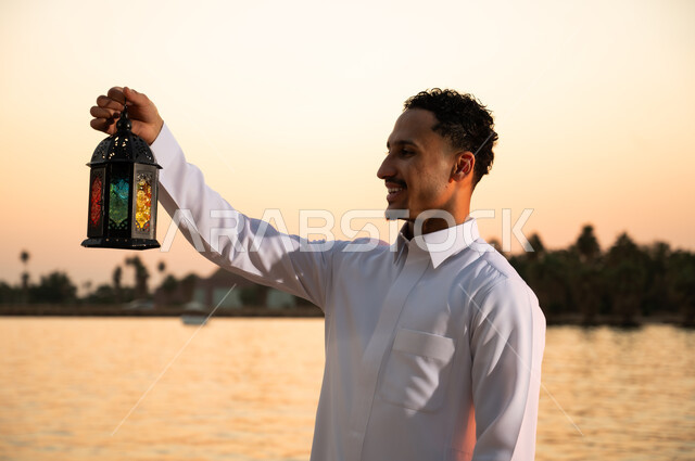 رجل سعودي يحمل فانوس رمضان وقت الغروب