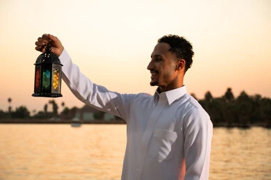 رجل سعودي يحمل فانوس رمضان وقت الغروب