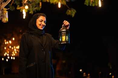 امرأة سعودية تحمل فانوس رمضان التقليدي ليلاً امرأة سعودية تحمل فانوس رمضان التقليدي ليلاً