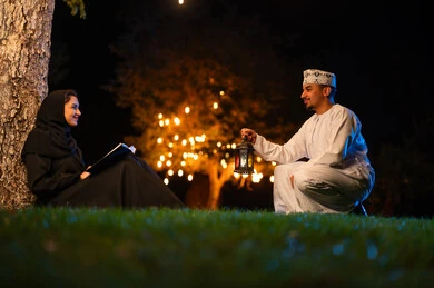 Omani Man with Lantern and Woman Reading at Night
