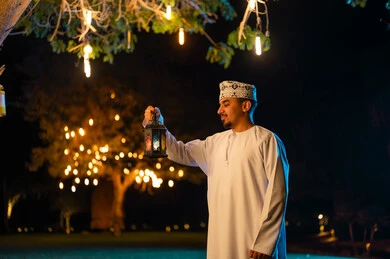 Omani Man with Traditional Lantern at Night