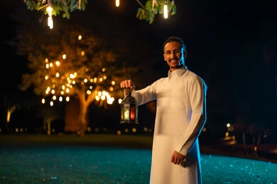 رجل سعودي يحمل فانوس رمضان في الليل