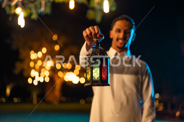 رجل سعودي يمسك فانوس رمضان التراثي في الليل
