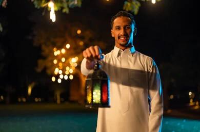 رجل سعودي يحمل فانوس رمضان في الليل