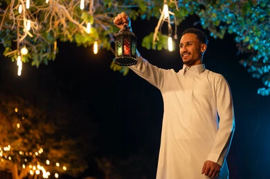 Saudi Man Holding Traditional Ramadan Lantern at Night