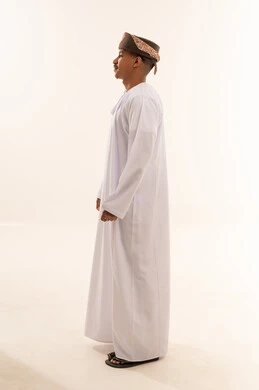 رجل عماني بالدشداشة والكمة التقليدية خلفية بيضاء