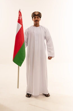 Omani Man in Traditional Dress Holding Oman Flag