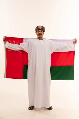 Omani Man Wearing Traditional Kumma Holding Oman Flag