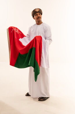 Omani Man in Traditional Dress Holding Oman Flag